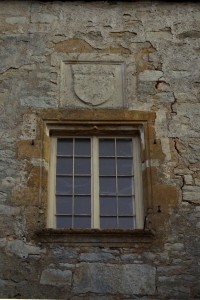 Charroux, abbaye Saint-Sauveur, porte de l’Aumônerie, détail de la fenêtre et de l'armoirie royale.